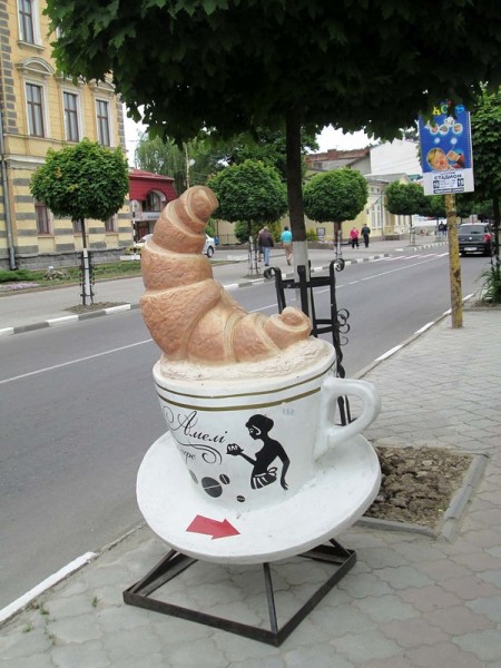 Advertising sculpture pillar of a cup of coffee with a croissant.